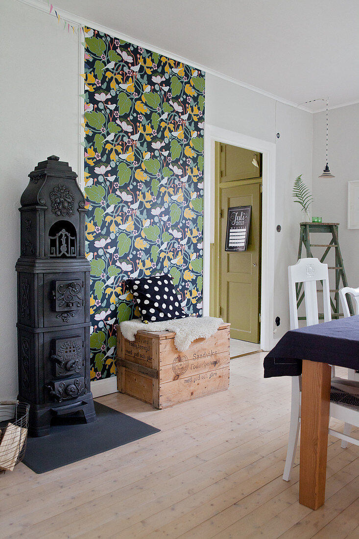 Old cast iron stove and retro wallpaper in rustic dining room