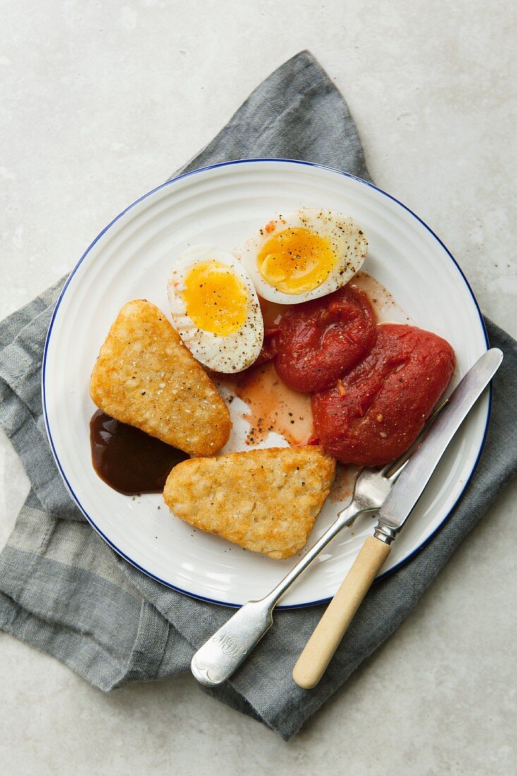 Vegetarisches Englisches Frühstück mit Kartoffelecken, Tomaten und Ei