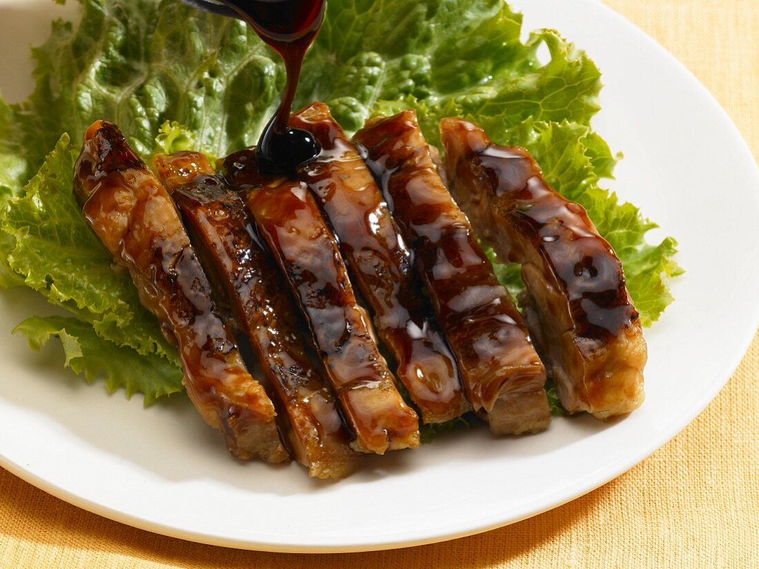 Asian ribs with sauce on a bed of lettuce