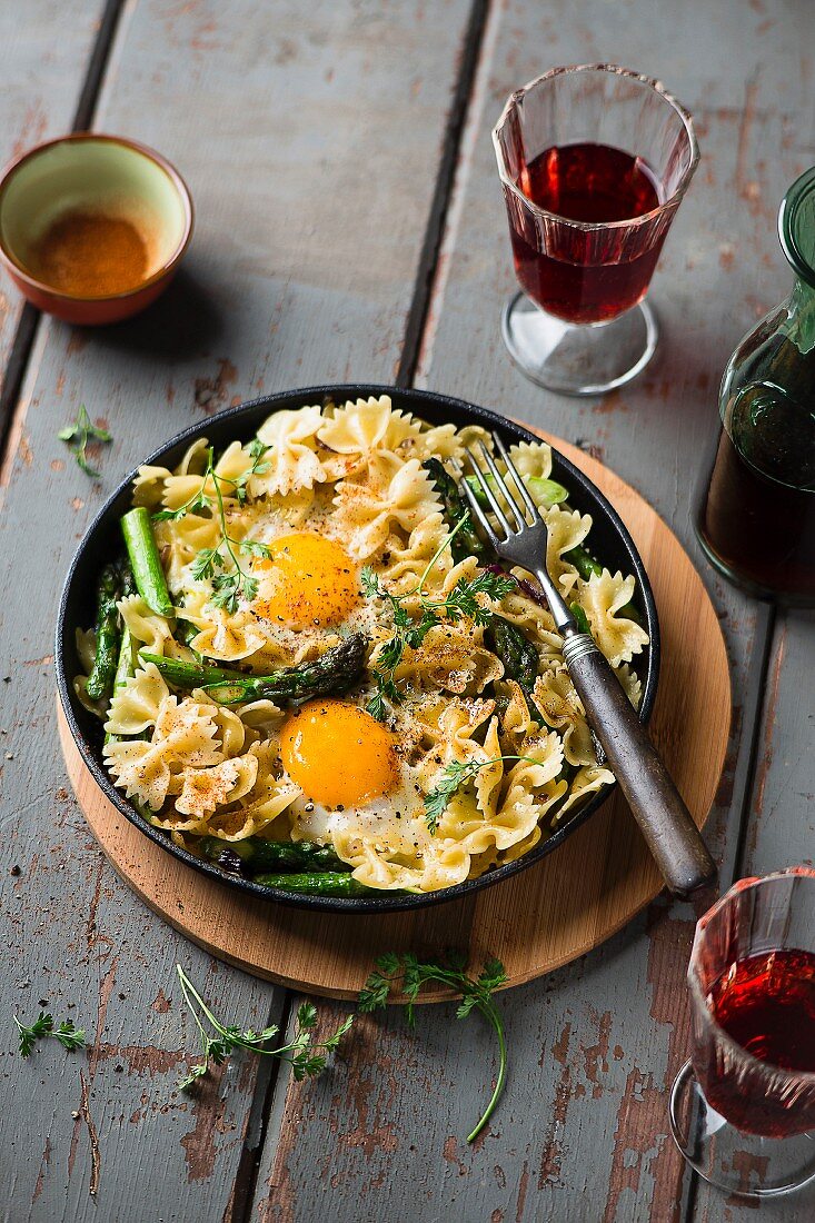 A pasta dish with asparagus and fried eggs