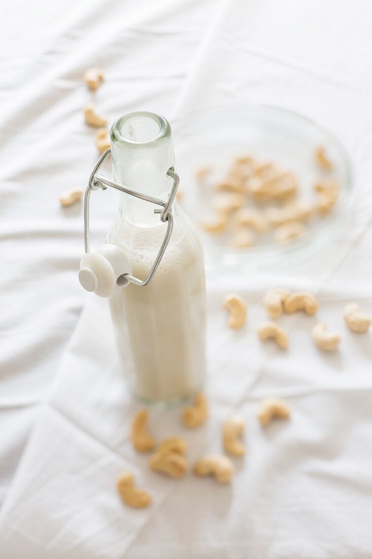 Homemade vegan cashew milk in a glass bottle