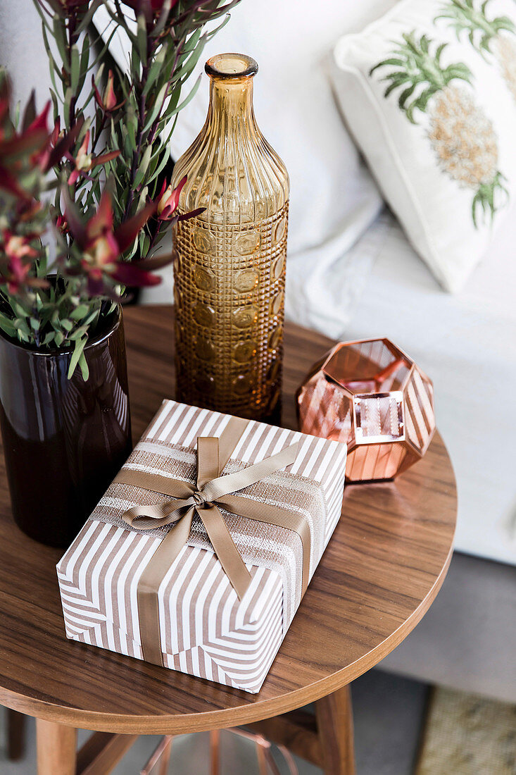 Wrapped gift on the bedside table with decoration in earth tones