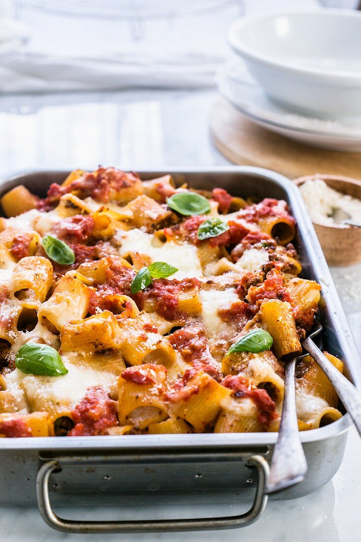 Pasta bake with ragout, mozzarella and bechamel sauce in a baking dish