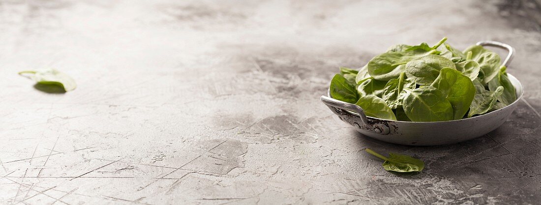 Fresh green spinach on rustic background