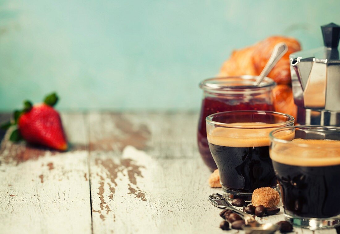 Frühstück mit frischem Kaffee, Erdbeermarmelade und Croissants