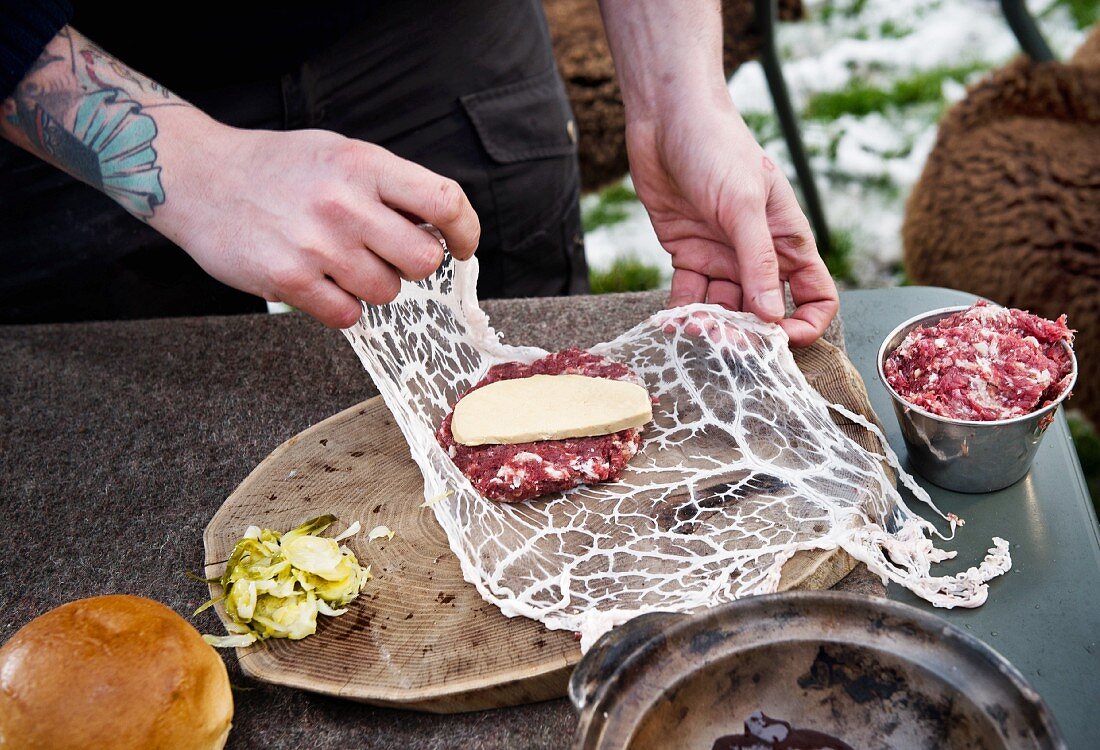 Burger fürs Camping zubereiten: Patties in Schweinenetz wickeln