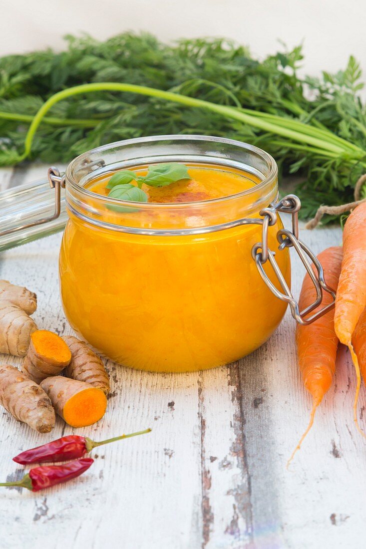 Carrot soup with turmeric, ginger and chilli in a flip-top jar