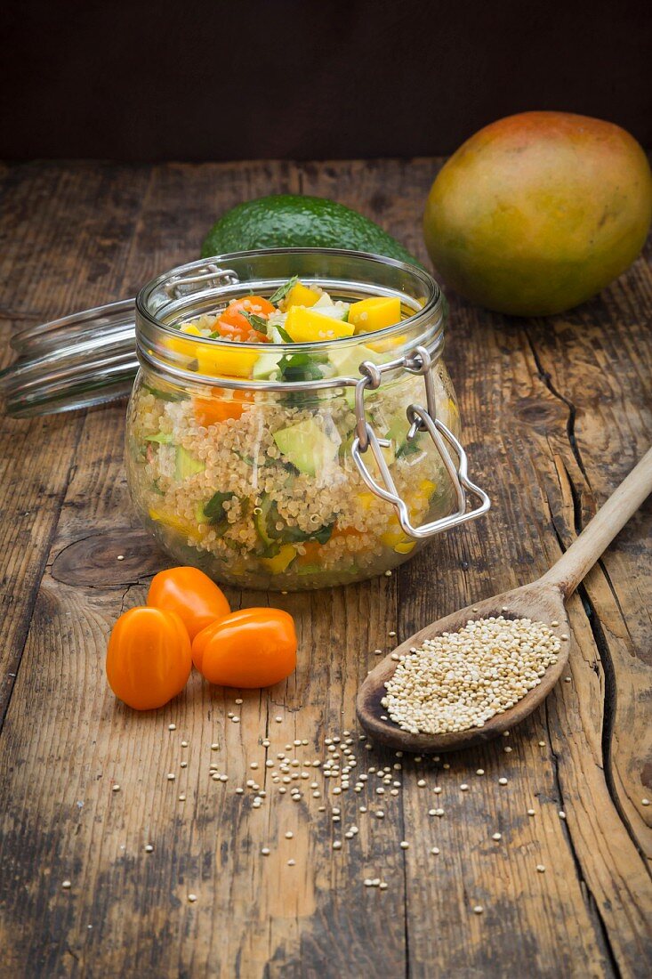 Quinoa salad with avocado, cucumber, tomato and mango in a glass jar