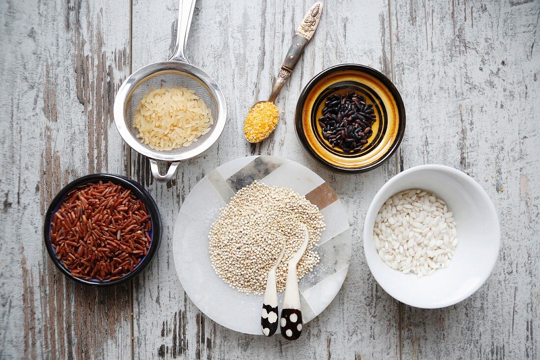 An arrangement of various types of rice, quinoa and couscous (seen from above)