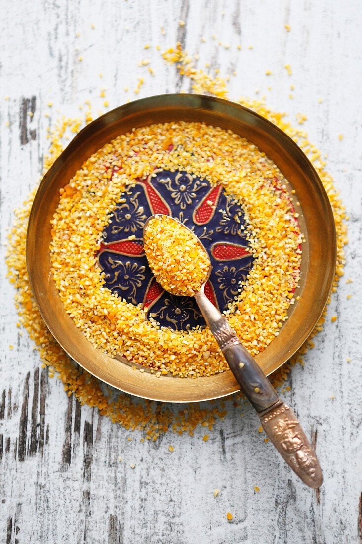 Couscous on a spoon and an oriental plate (seen from above)