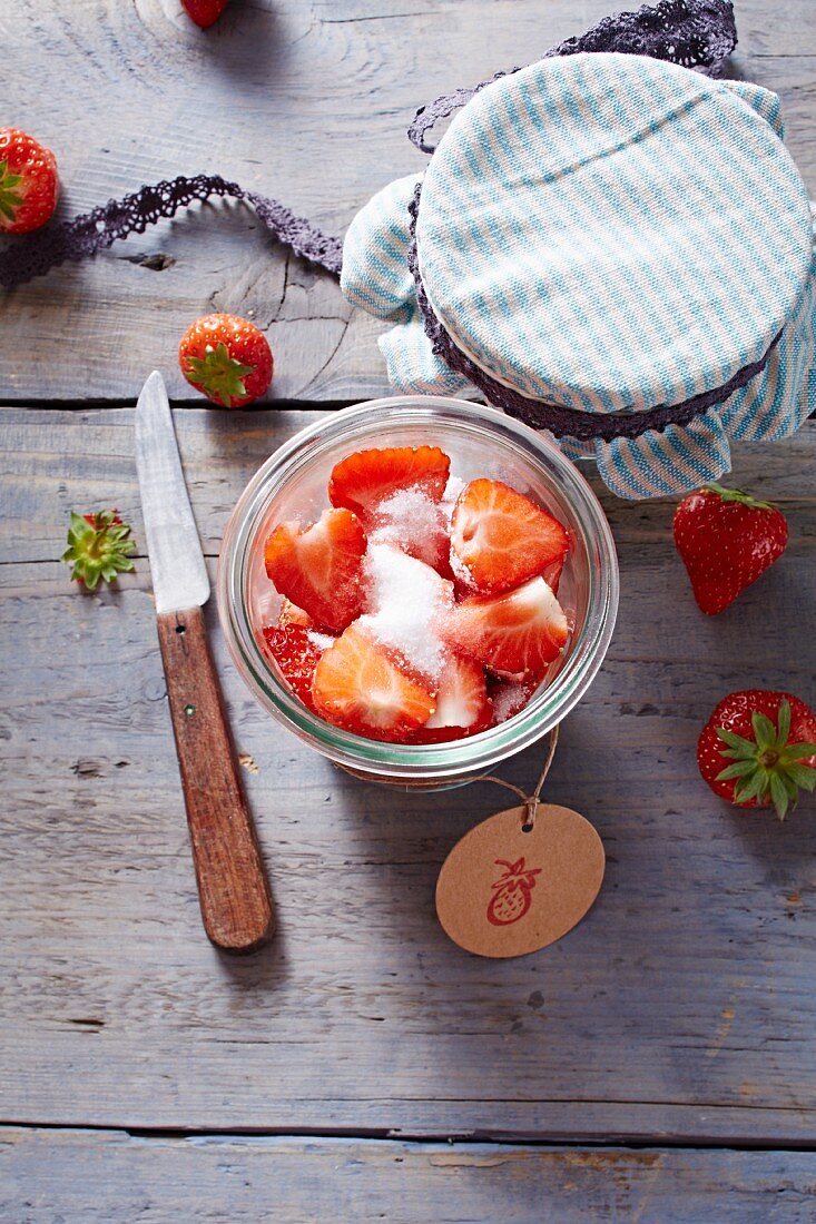 Strawberries with sugar in a glass jar