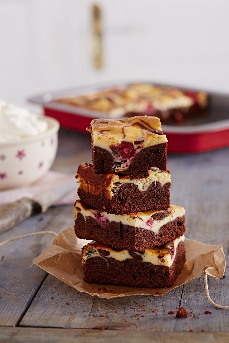 Several pieces of cherry and chocolate cake, stacked