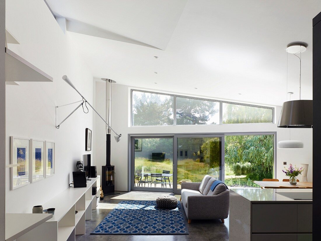 Log-burning stove in open-plan interior with view of garden