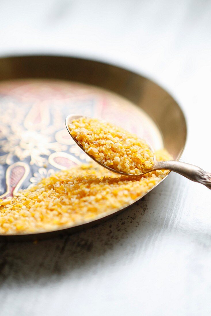 Couscous on a spoon and an oriental plate