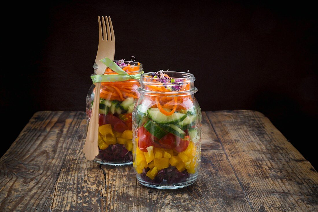 Rainbow-Salad im Glas mit Rotkohl, gelber Paprika, Tomaten, Gurke, Karotten und Rote-Bete-Sprossen