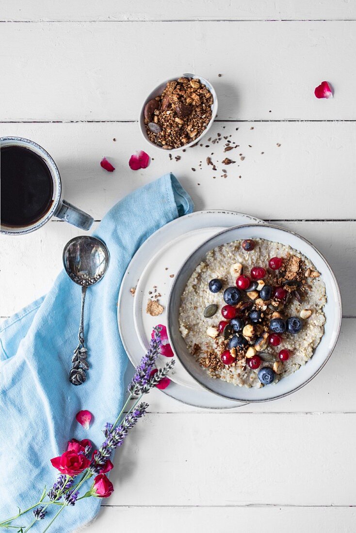 Quinoa-Porridge mit frischen Beeren, dazu eine Tasse Kaffee