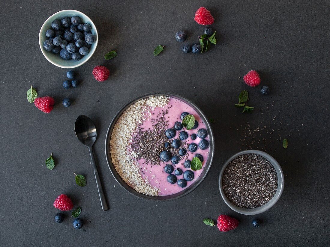 A pink smoothie bowl with berries and gluten-free millet flakes (seen from above)