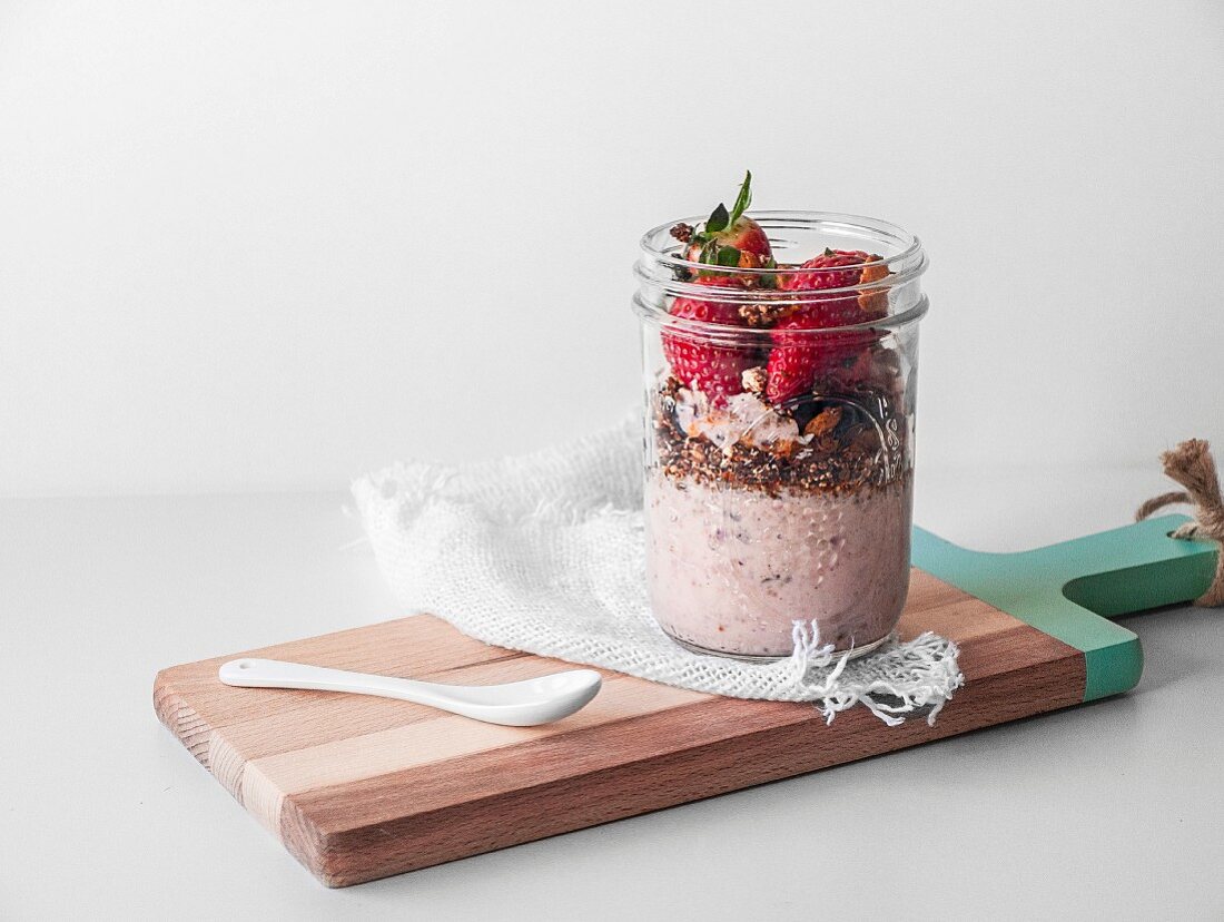 Veganes Frühstück im Glas mit Joghurt, Müsli und Erdbeeren