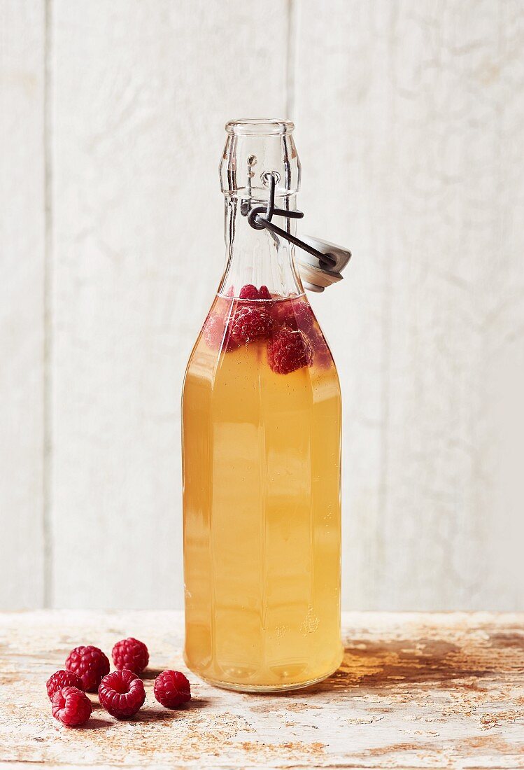 Homemade Kombucha tea with raspberries in a bottle