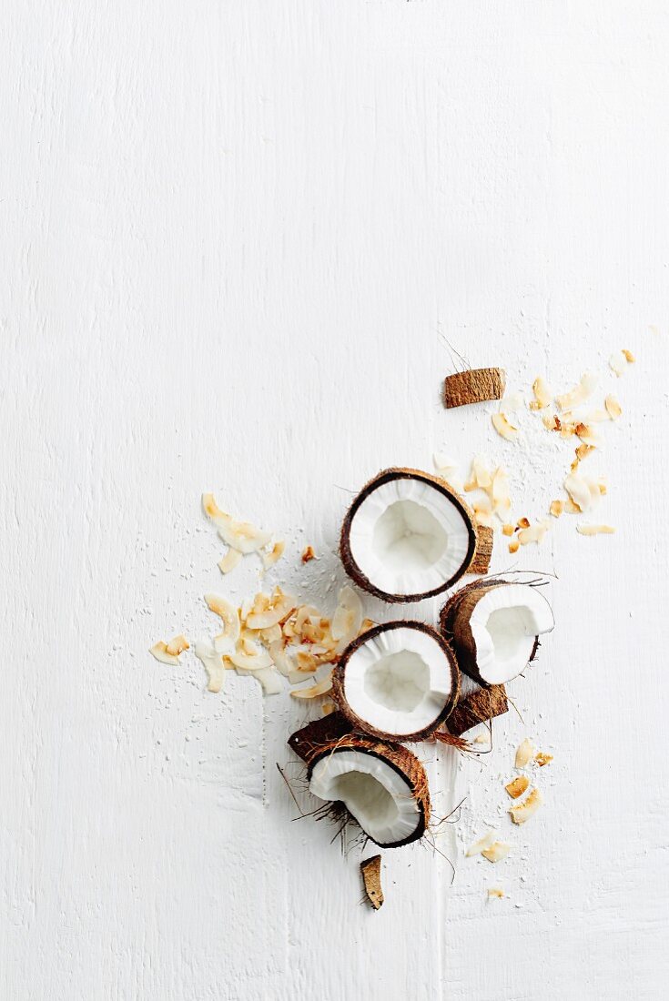 Stillleben mit frischen Kokosnüssen und getrockneten Kokosspänen (Draufsicht)