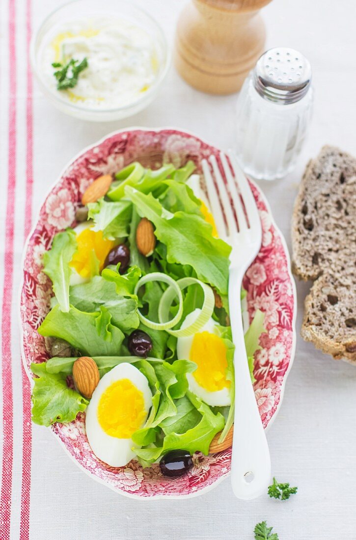 Blattsalat mit Ei, Oliven und Mandeln