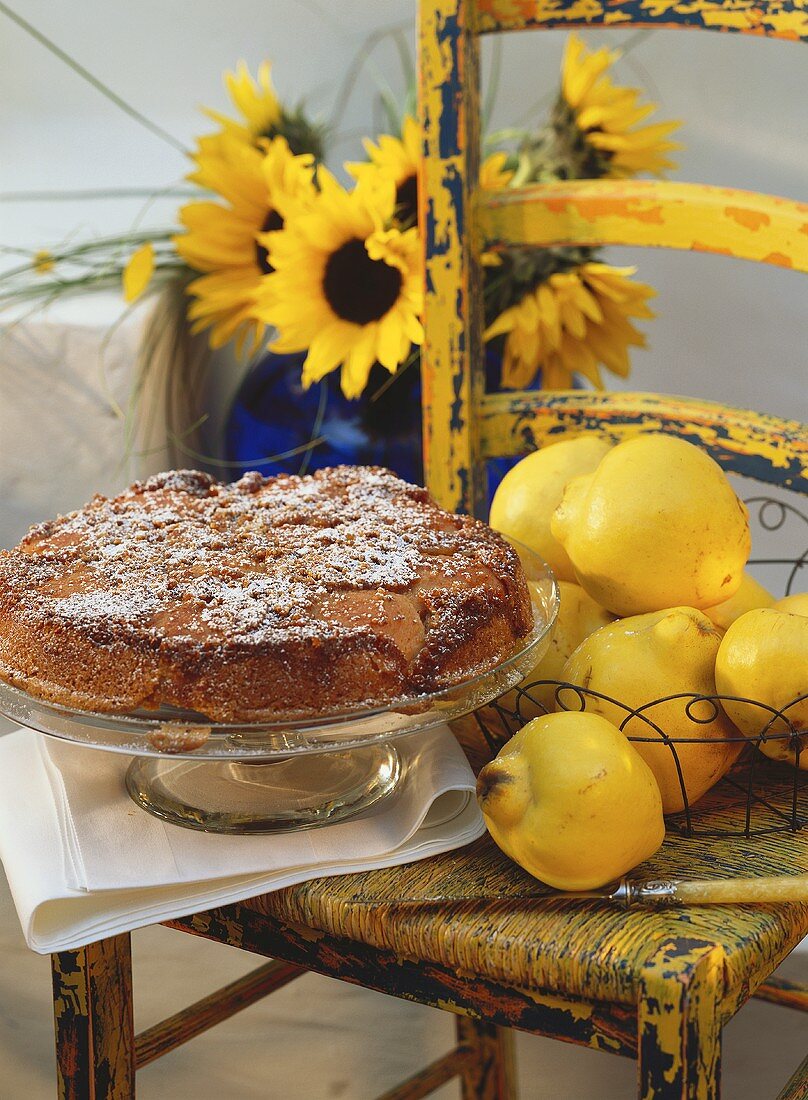 A quince tart on cake plate; fresh quinces