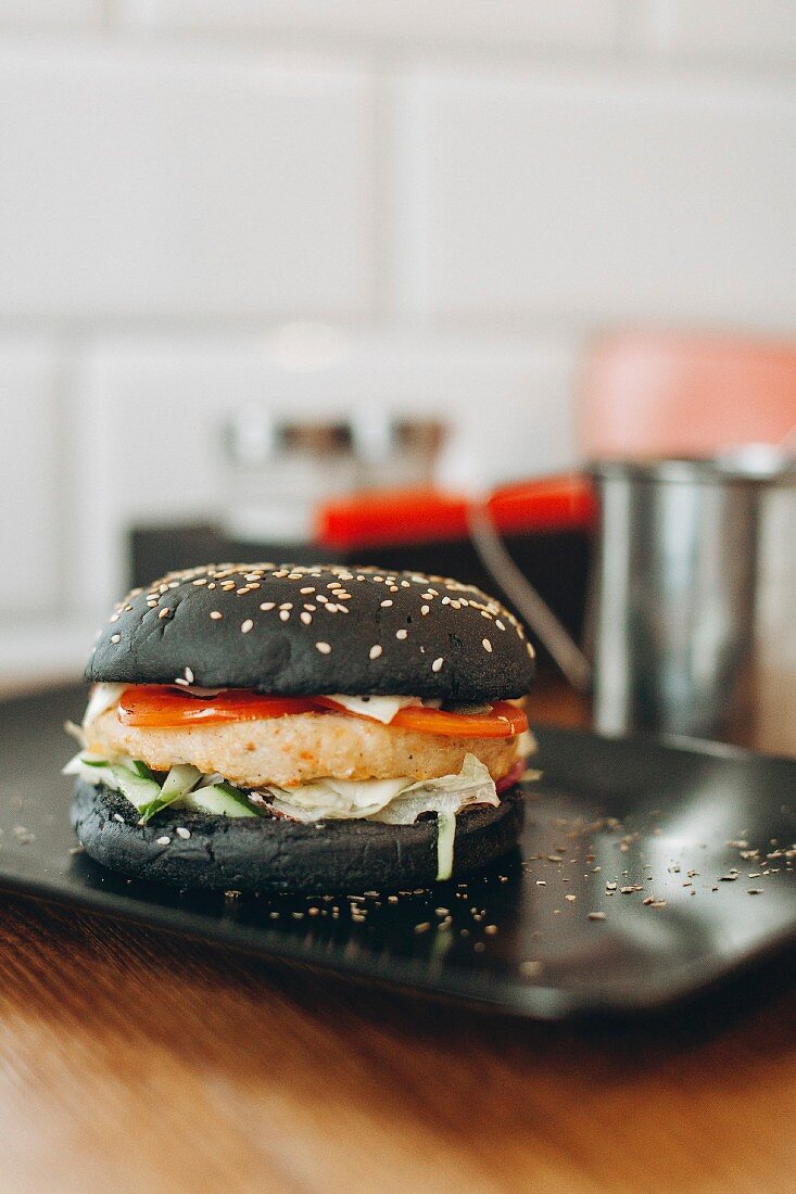 Schwarzer Burger mit Käse, Tomaten und Salat