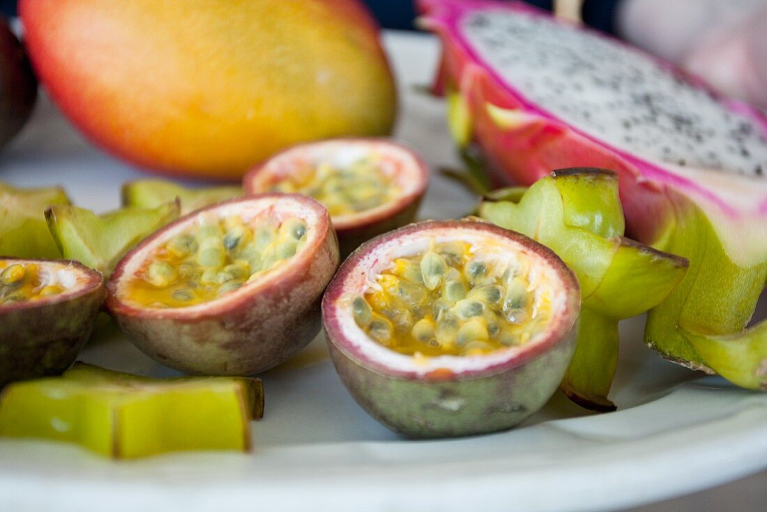 Exotischer Früchteteller mit Passionsfrucht, Sternfrucht, Mango und Pitahaya