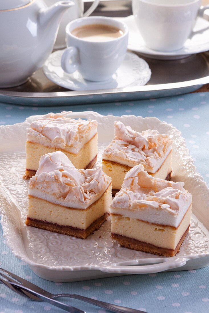 Vier Stücke Käsekuchen mit Baiserhaube, Kaffee