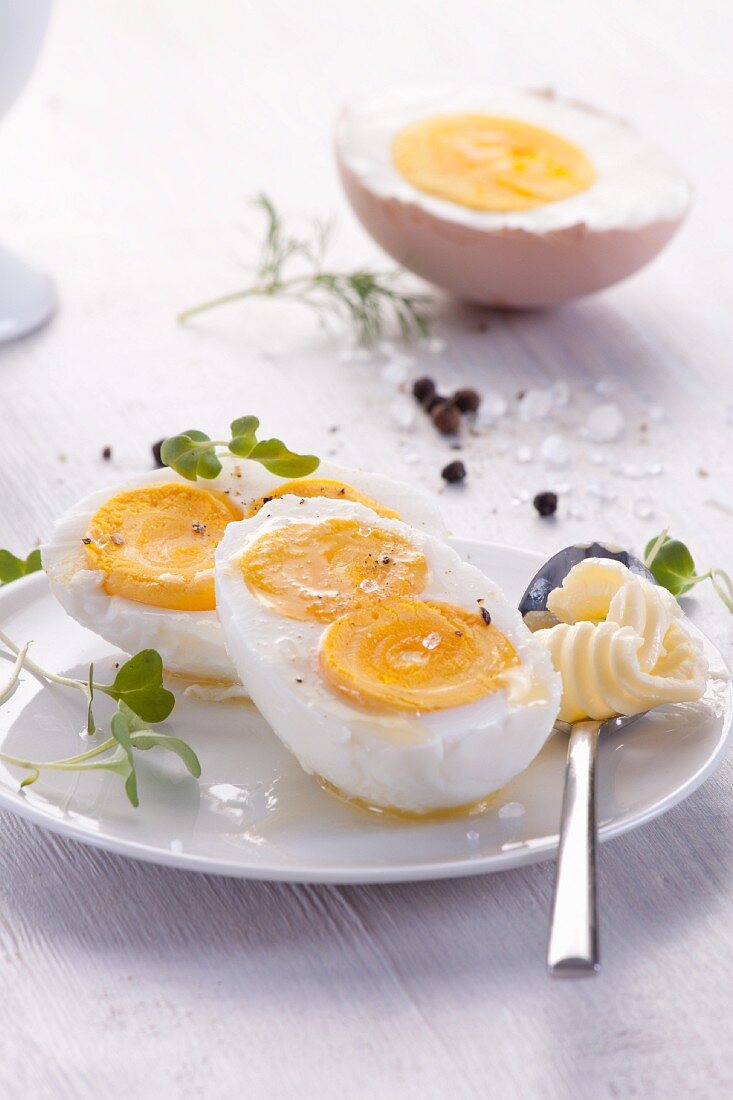 Halbes gekochtes Ei mit zwei Eigelben, Salz und Butter