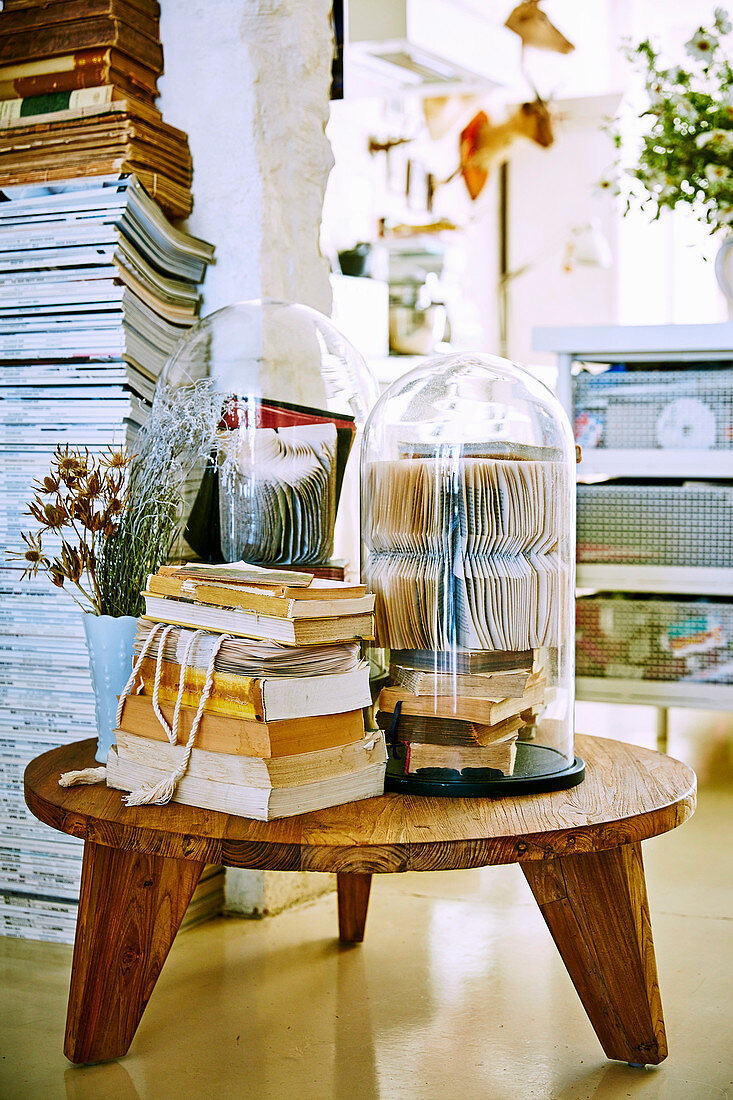 Holzhocker mit Büchern und Glashauben