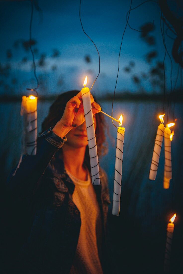 Woman lighting candles outside