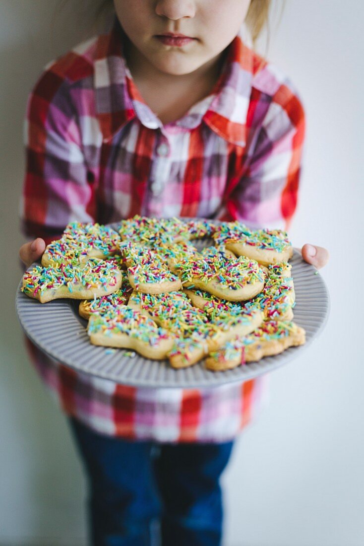 Girl holding plate of cookies