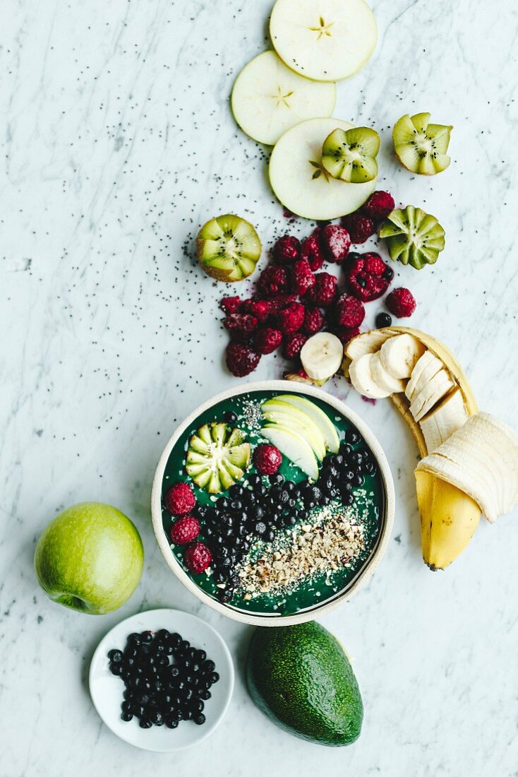 Grüne Smoothie-Bowl mit Avocado und Früchten zum Frühstück (Aufsicht)