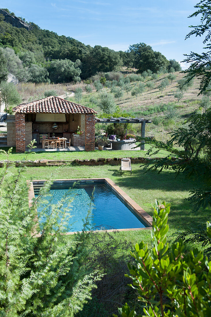 Mediterraner Garten mit Pool und überdachter Terrasse