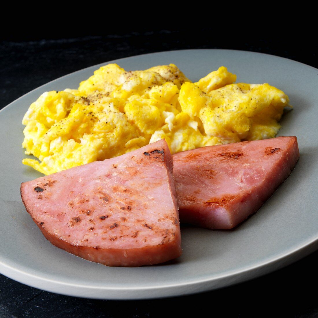 Fried breakfast ham with scrambled eggs