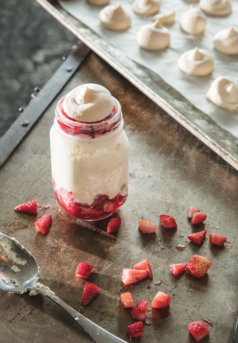 Meringue-Dessert mit Erdbeeren im Einmachglas serviert