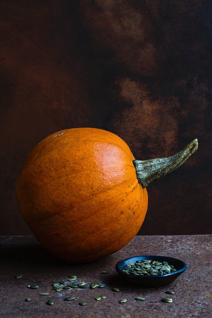 An orange pumpkin for Halloween and pumpkin seeds