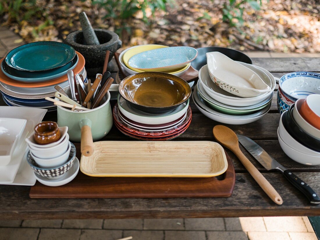 A collection of crockery on a wooden table outdoors