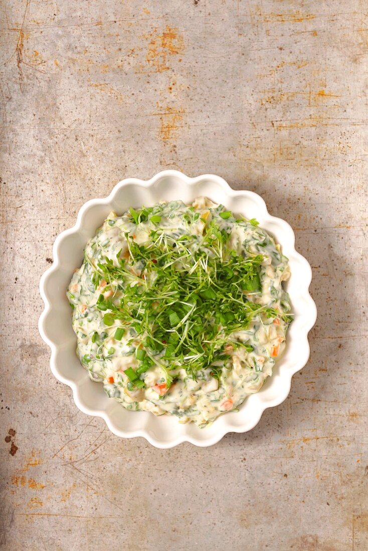 Mayonnaise dip with olives and herbs in a small bowl on a stone background