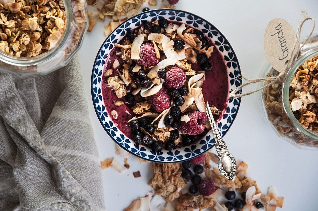 Smoothie-Bowl mit Granola, Himbeeren und Heidelbeeren