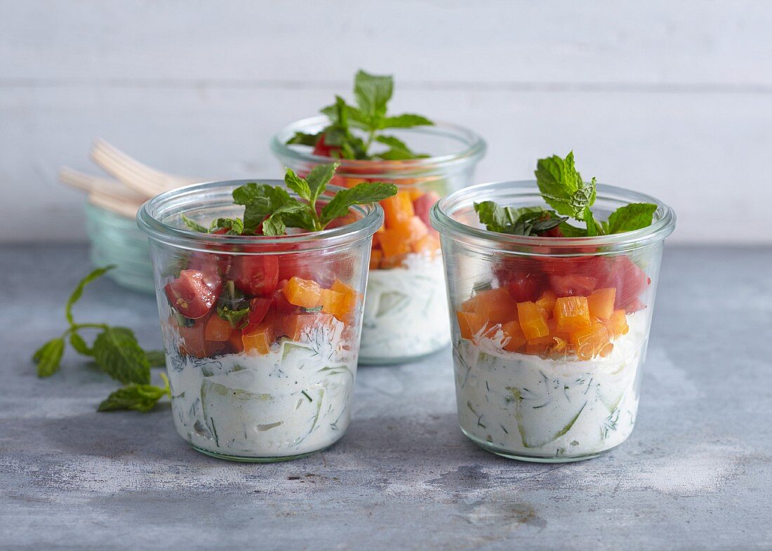 Layered salad with cucumber, orange pepper, tomatoes and Greek yoghurt