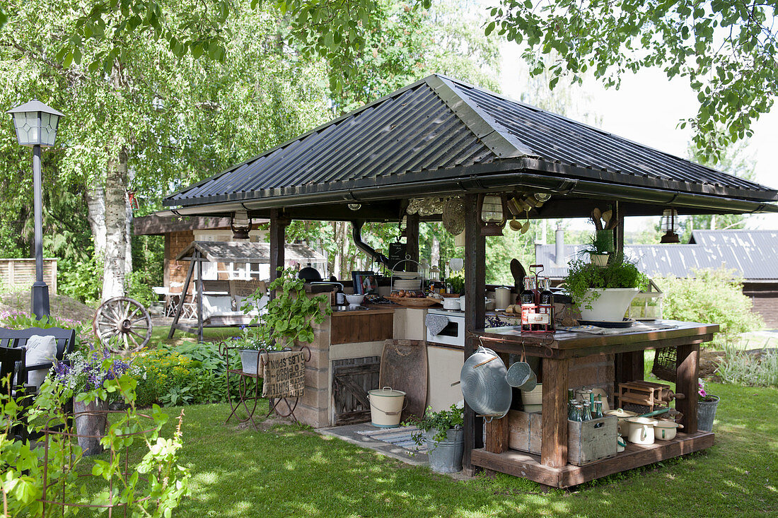 Outdoor kitchen with roof in summery garden