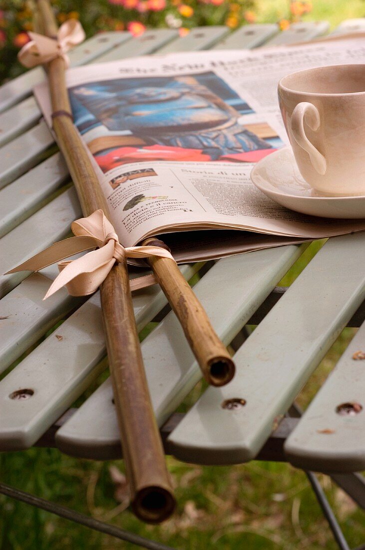 Newspaper in bamboo holders and teacup