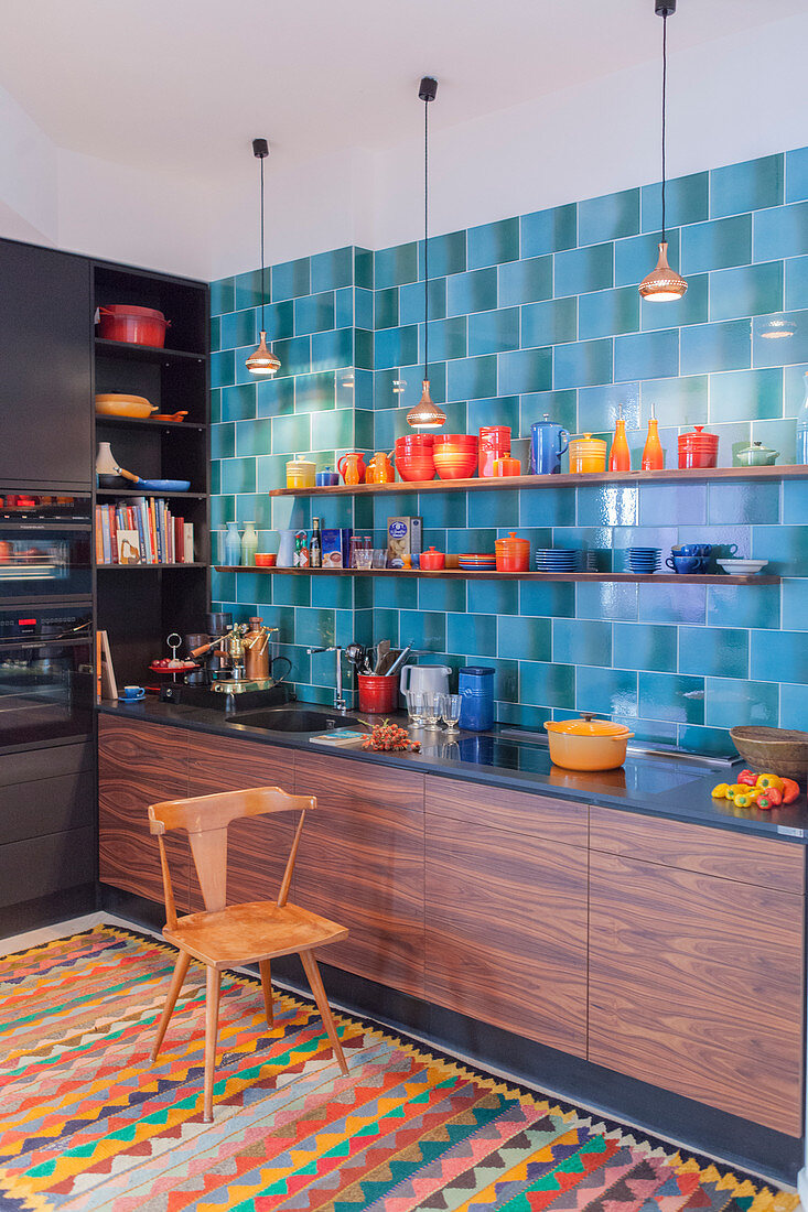 Blue retro wall tiles and colourful crockery in modern kitchen