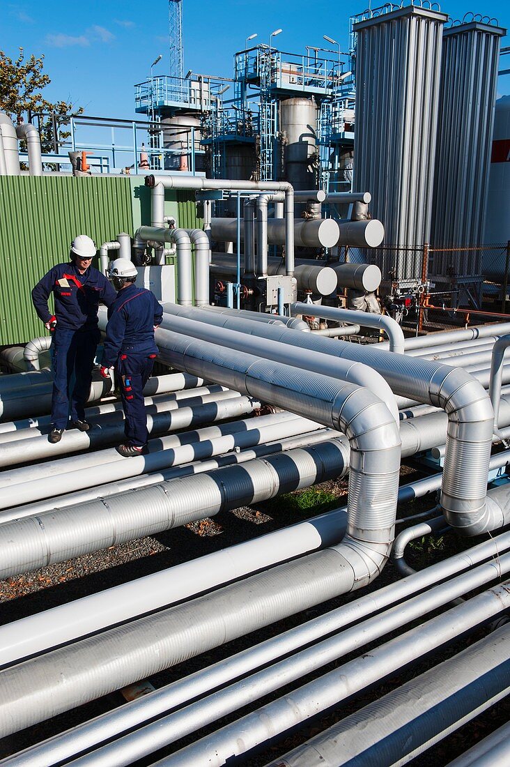 Workers checking pipework on an oil and gas refinery