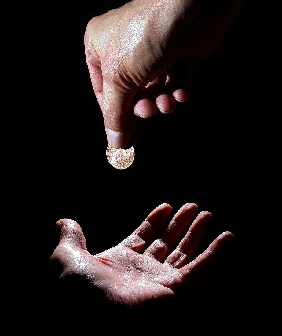 Person dropping coin on palm of hand
