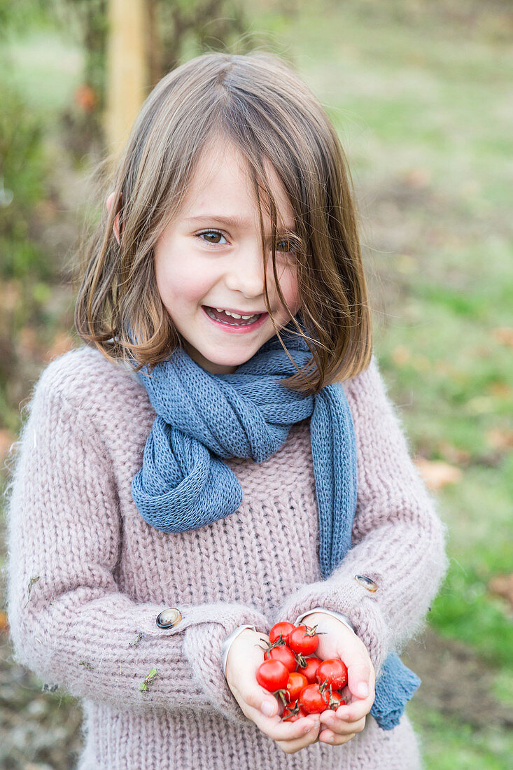 Girl holding tomatoes from garden