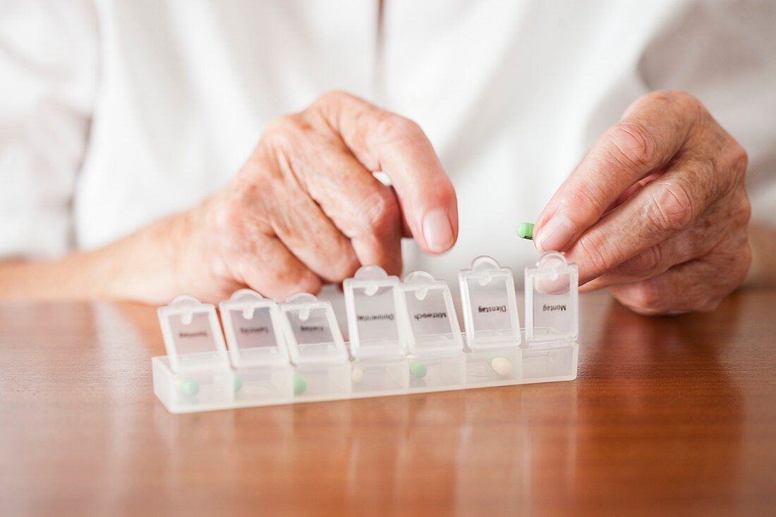 Elderly woman using a pill box
