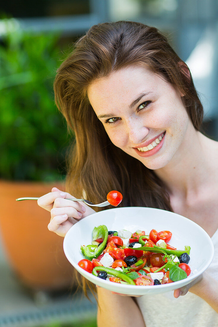 Woman eating a Mediterranean salad